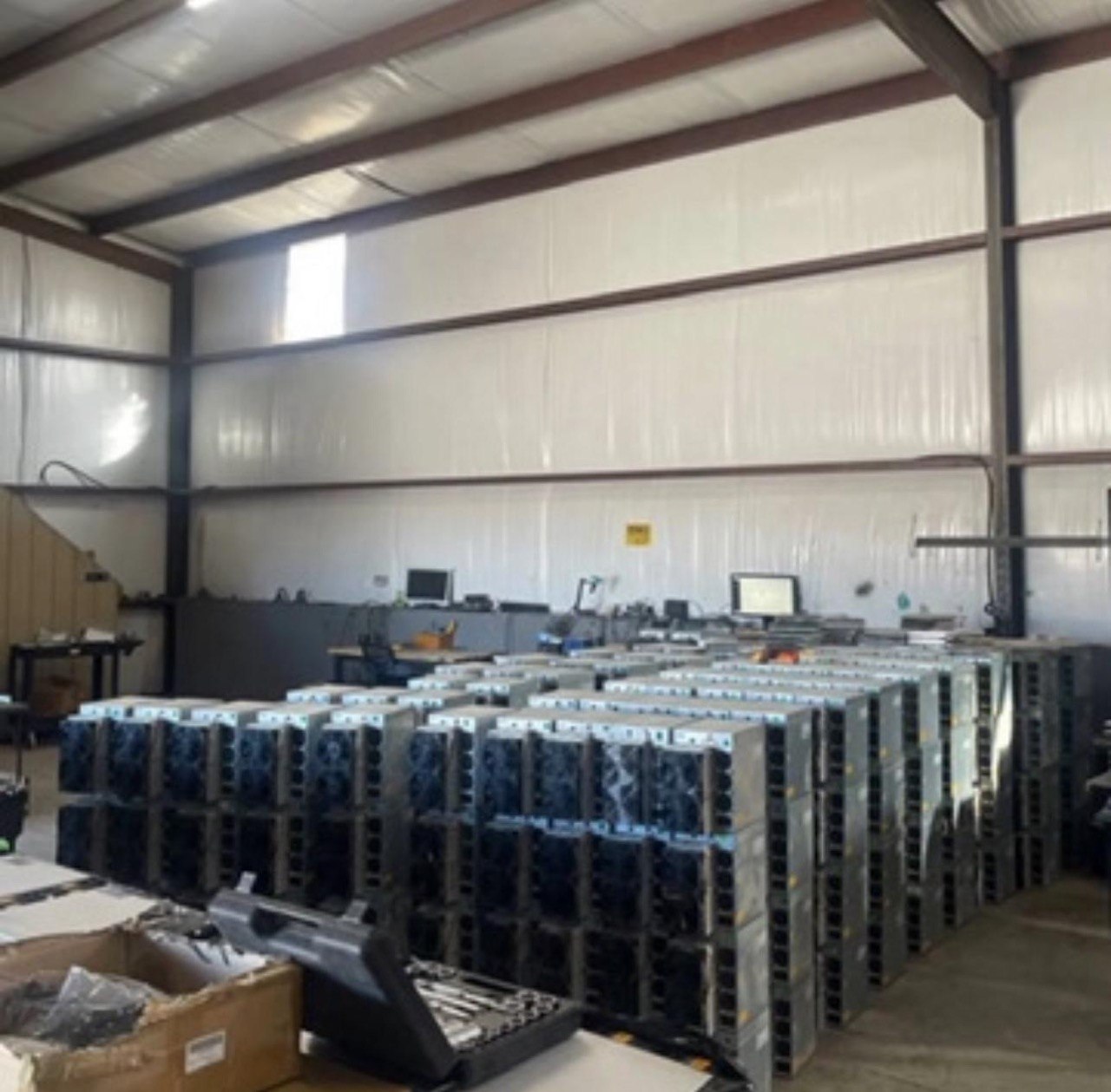 OCA warehouse — ground-level view of stacked mining hardware